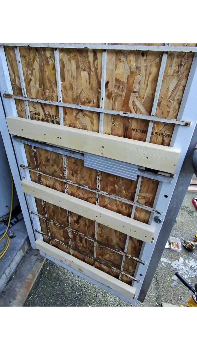 Aluminum storefront door boarded up with OSB sheeting and wood bracing after a break-in